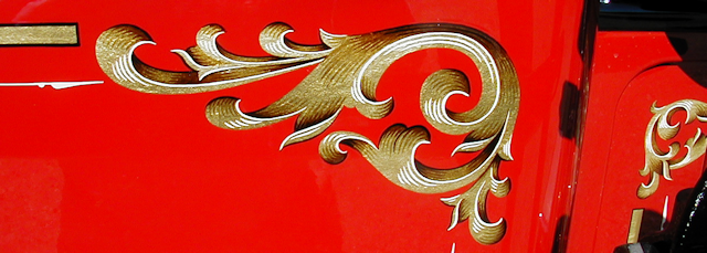Close-up of hand painted gold leaf scroll on an Ahrens-Fox hose body.